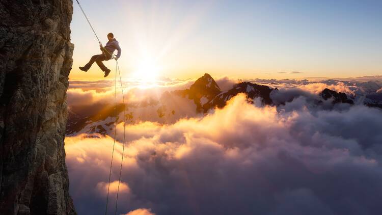 Someone climbing the cliffs above clouds