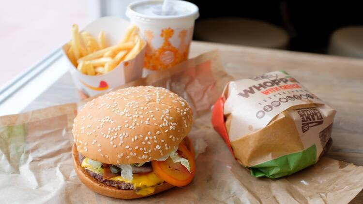 Close up of a Burger King Whopper with cheese burgers, fries and soft drink served at a Burger King