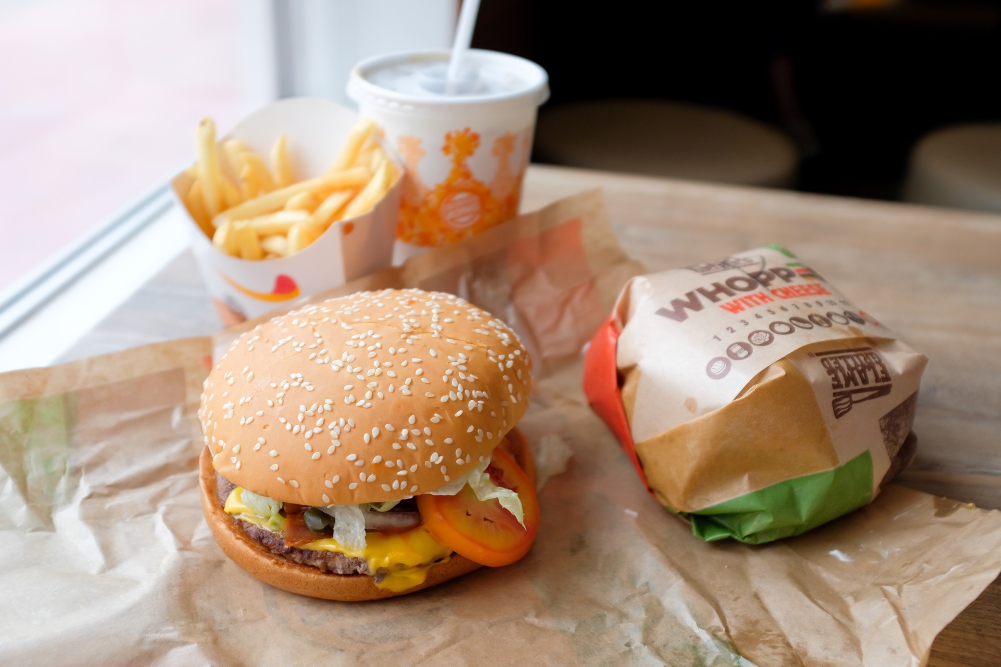 Close up of a Burger King Whopper with cheese burgers, fries and soft drink served at a Burger King