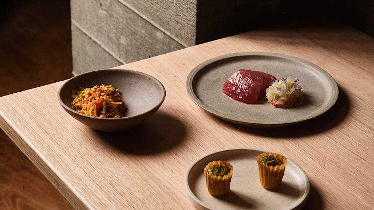 Assorted Southeast Asian-inspired dishes on a wooden table at Sunda. 