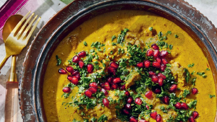 Iranian stew with pomegranate seeds and golden cutlery.