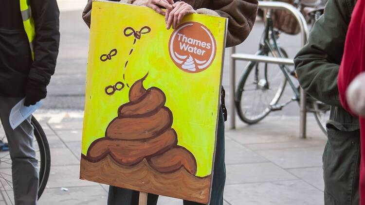Protestor with placard protesting sewage pollution in the Thames