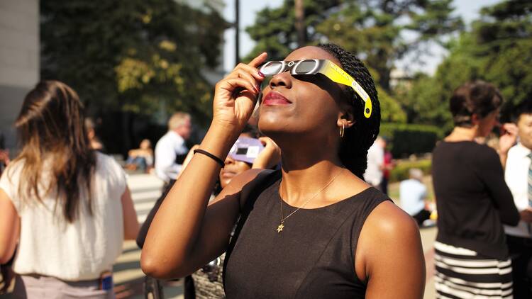 Person watching solar eclipse with glasses