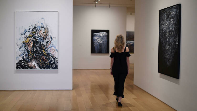 A woman views paintings by Artist Maggi Hambling at the Marlborough Fine Art gallery. PA Images / Alamy Stock Photo. 