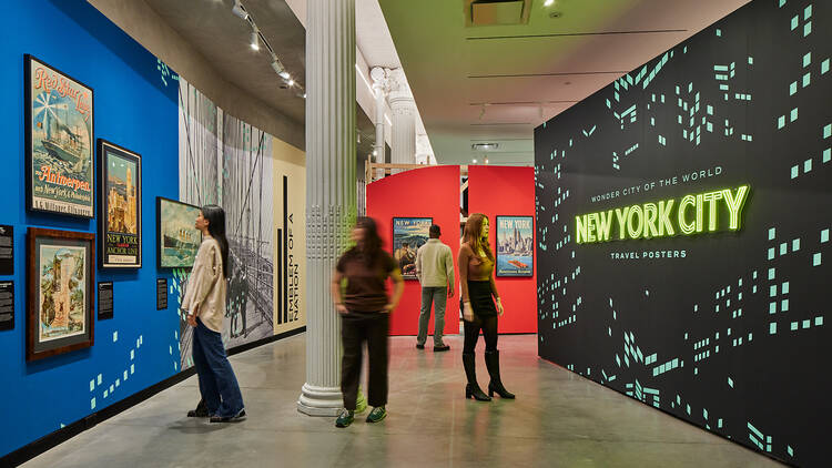 Museum-goers look through at New York City exhibit at Poster House.