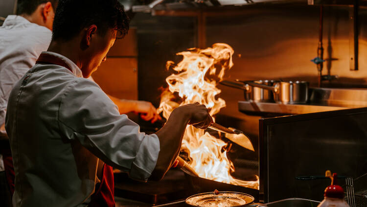 A chef cooking over fire at Morena