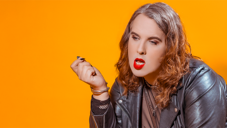 Anna wearing a leather jacket and red lipstick against a orange background