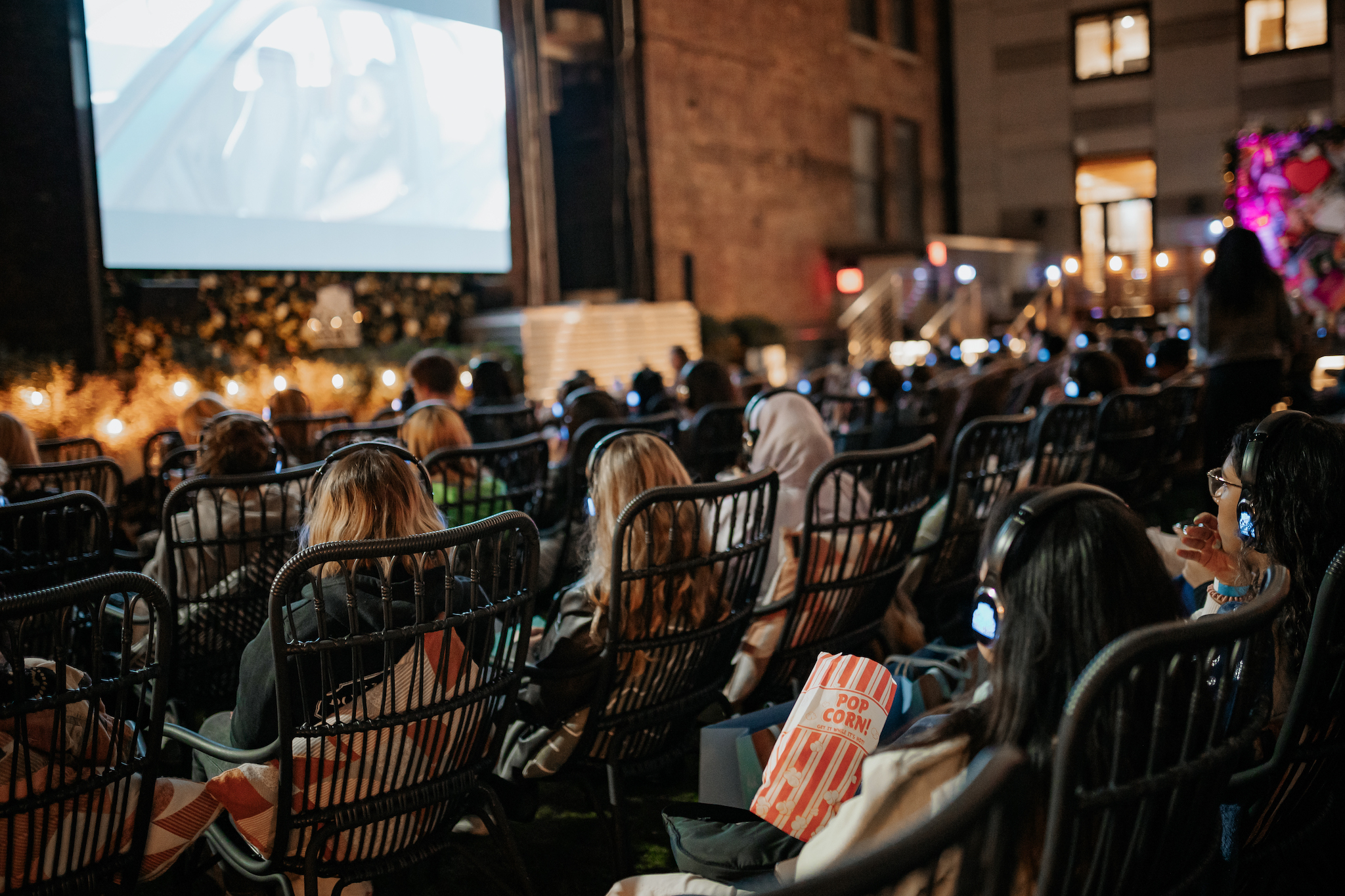 People wear headphones while watching a movie at Rooftop Cinema Club.