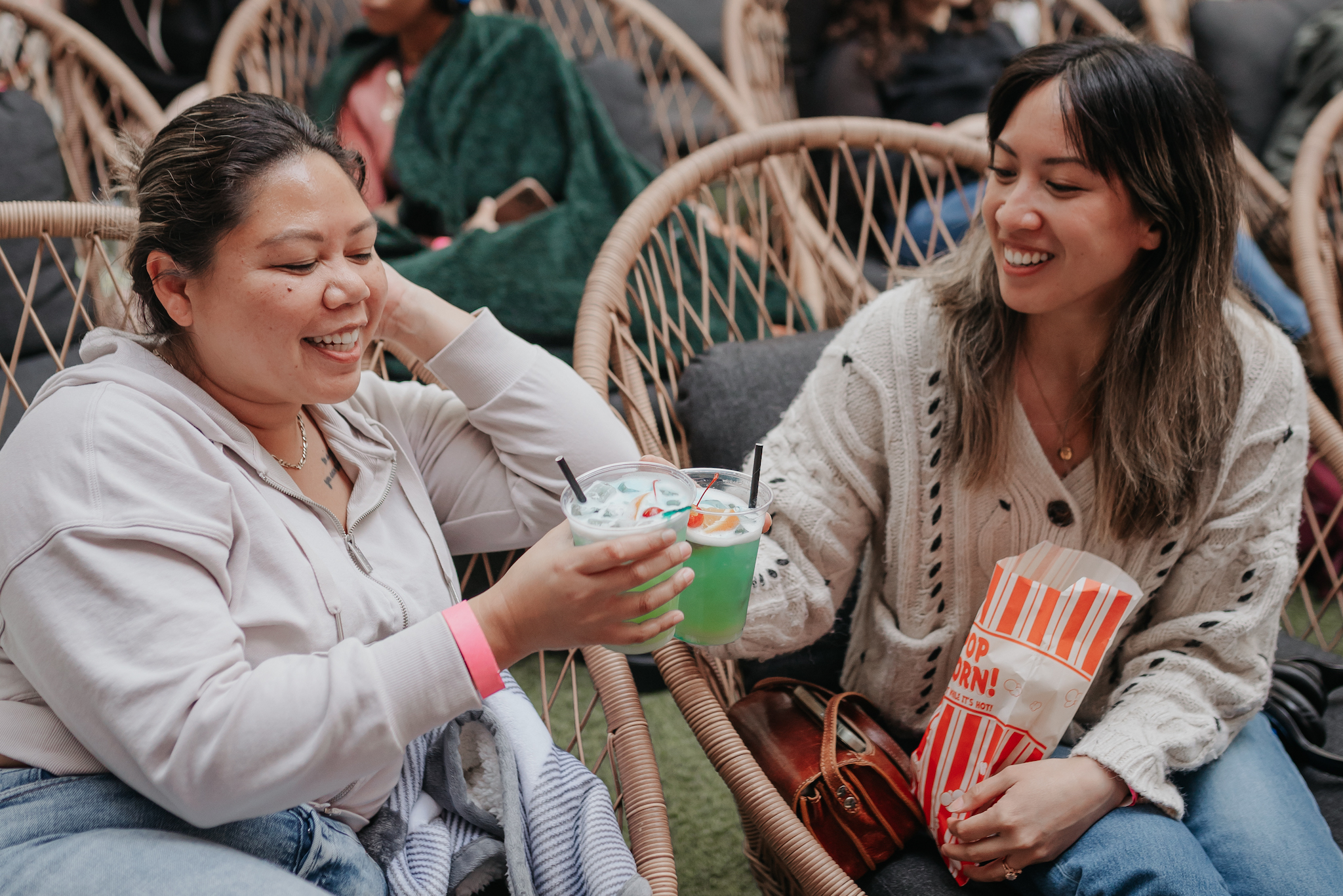 Two women hold cocktails at Rooftop Cinema Club.