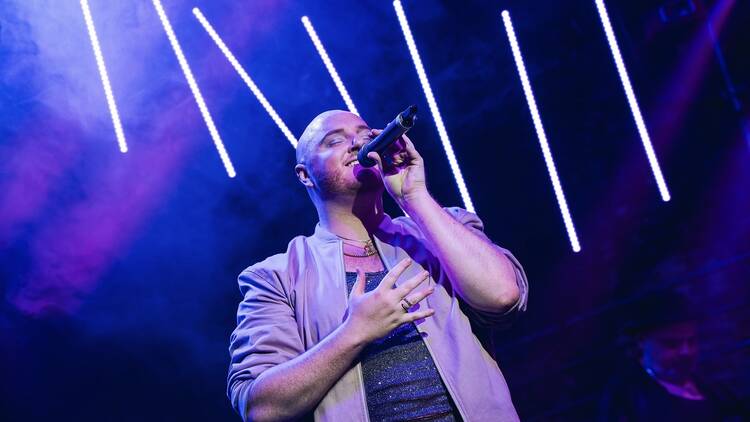 A singer on stage holds a microphone.