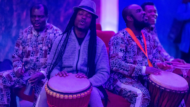 A group of performers sitting with drums