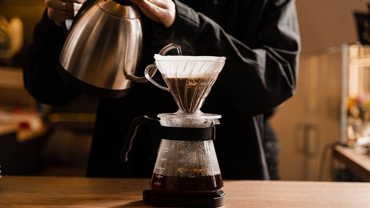 Barista pouring water into drip coffee