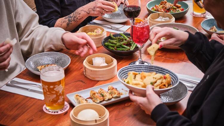 Group of friends enjoying assorted dumplings at Welcome to Brunswick.