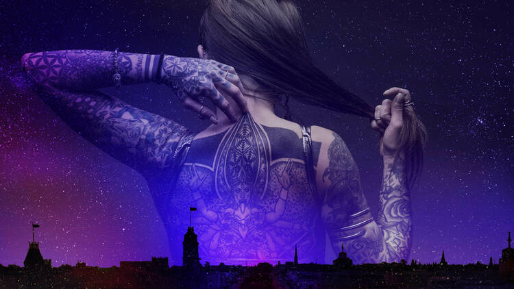 Woman with large back tattoo projected onto the night sky