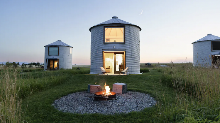 Three tin capsule homes near a fire pit on Clark Farm Montana. 