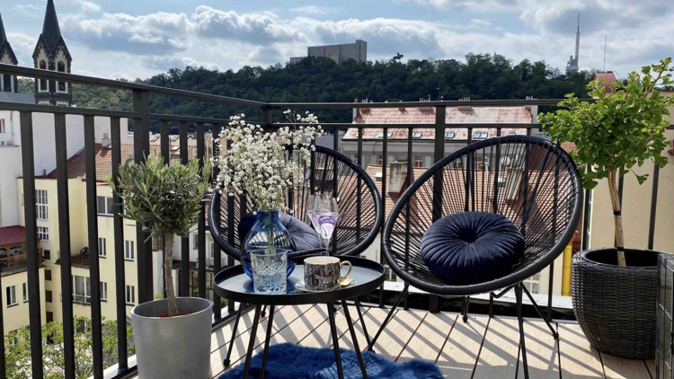 Balcony with two chairs and a small table in Airbnb rental in Karlin, Prague.