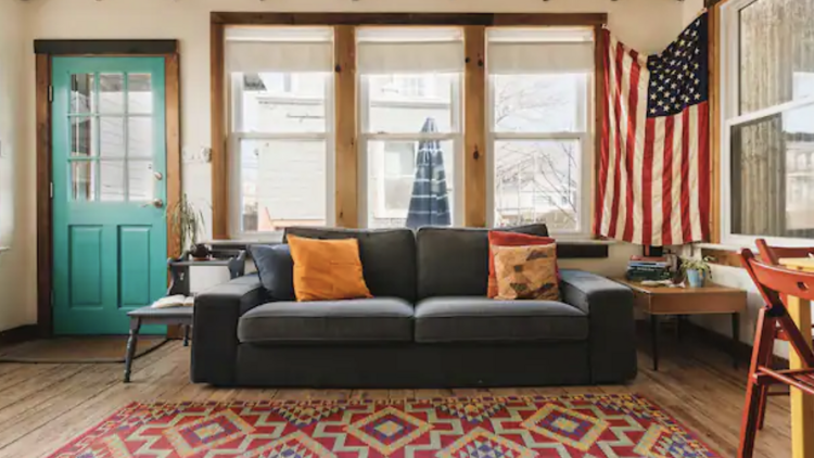 Living room with gray sofa  and rug in Rockaway Beach bungalow.