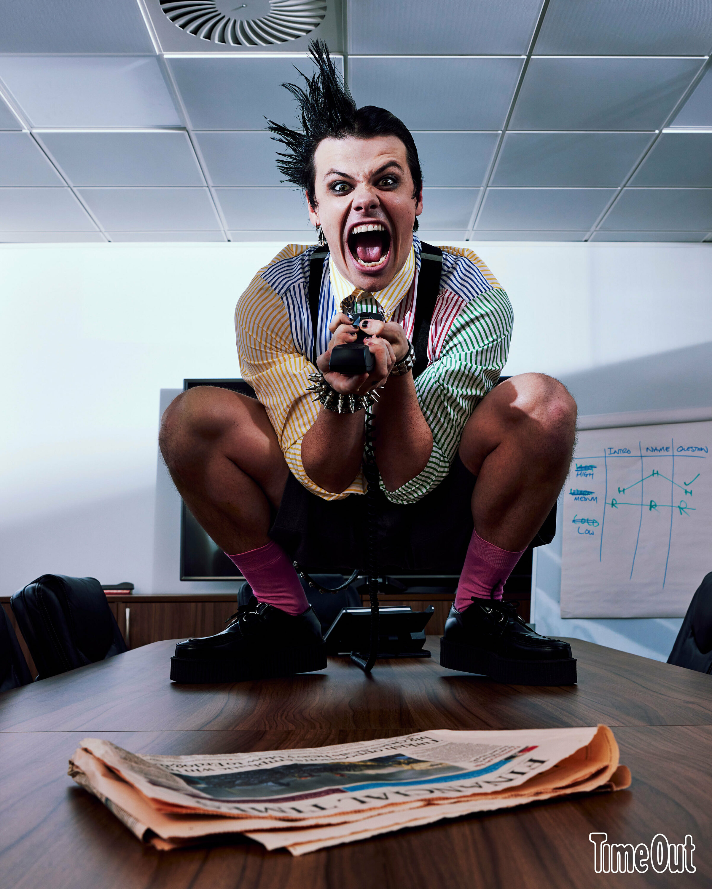 Yungblud sitting on a desk table