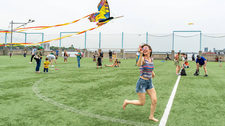 A woman flies a butterfly-shaped kite.