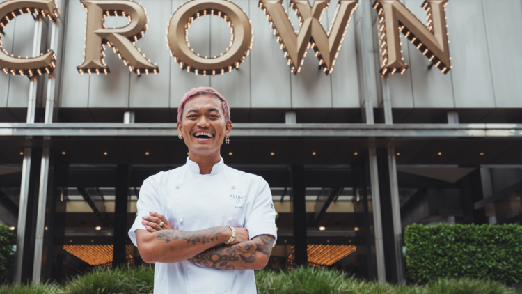 Masterchef star Khanh Ong smiling for the camera in front of Crown Melbourne complex.