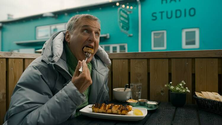 Phil rosenthal eating a bite of food