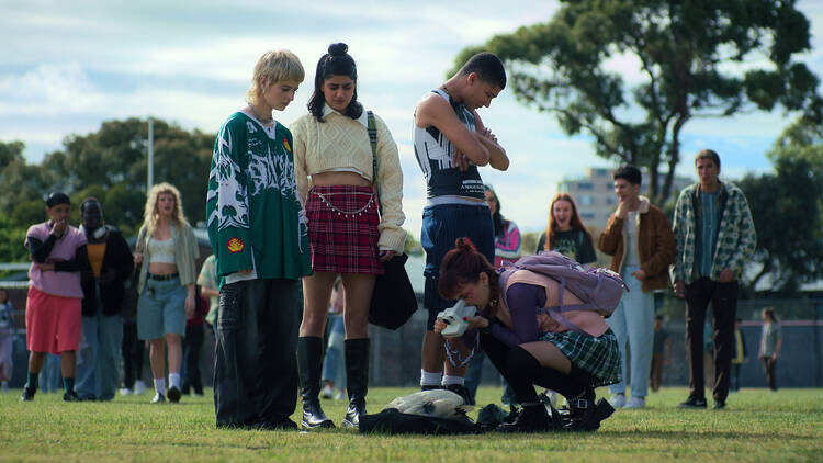 Amerie, Harper, Darren and Quinni stare at a dead bird on the oval