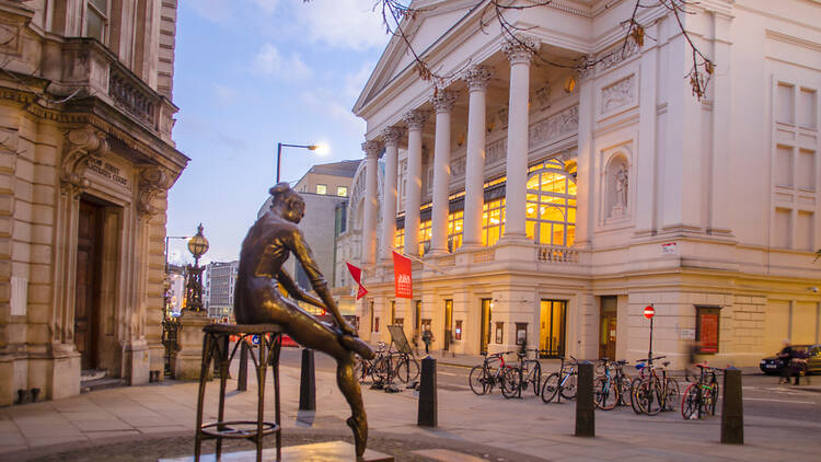 Evening view of the Royal Opera House from outside in the front of the picture is the ballet statue