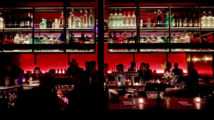 silhouttes of people at a bar with red lighting