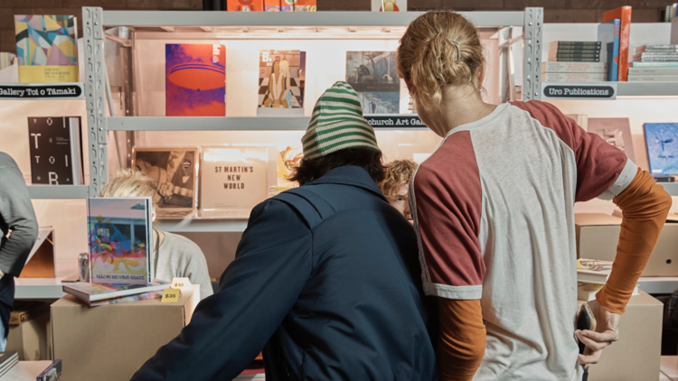 Two people look at a book stall