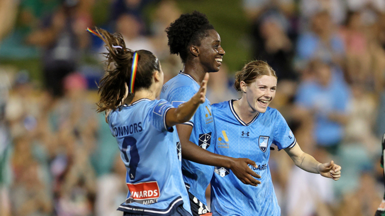 Female professional football players celebrating