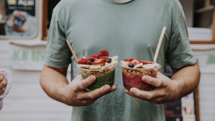 Man holding two acai bowls