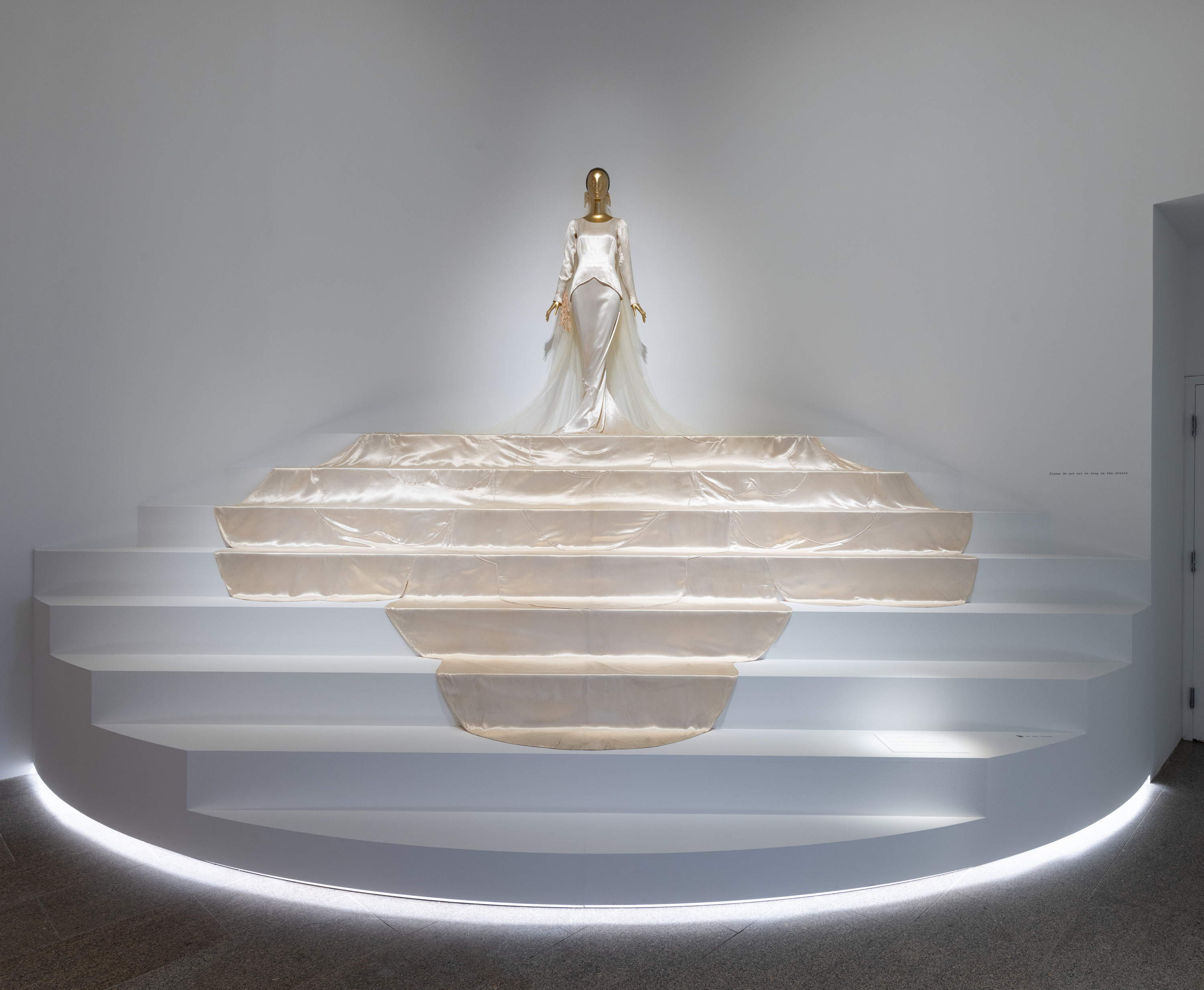 A Depression-era wedding gown displayed on a staircase.