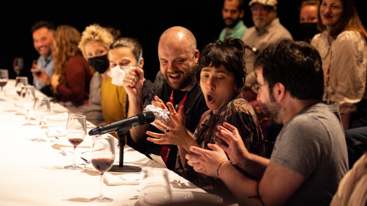 A dinner guest holds foil in front of a microphone