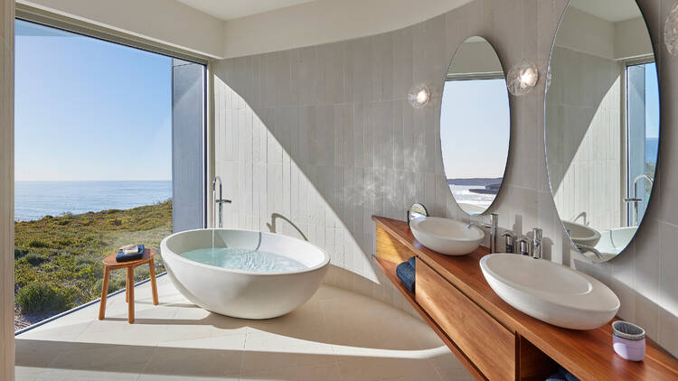 Fancy bathroom with bath overlooking water