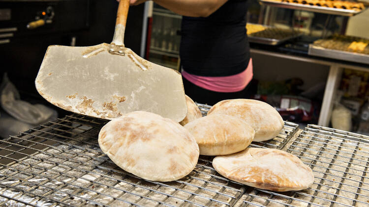 Fresh pita bread coming out of oven