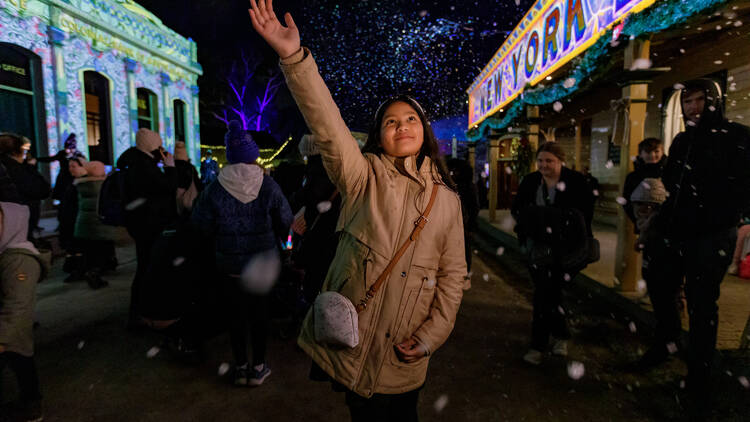 Girl raises hand to falling snow