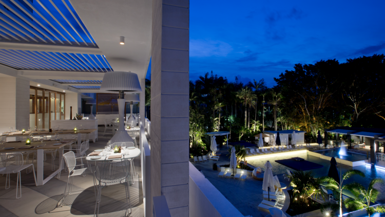 Hotel balcony restaurant overlooking pool at night