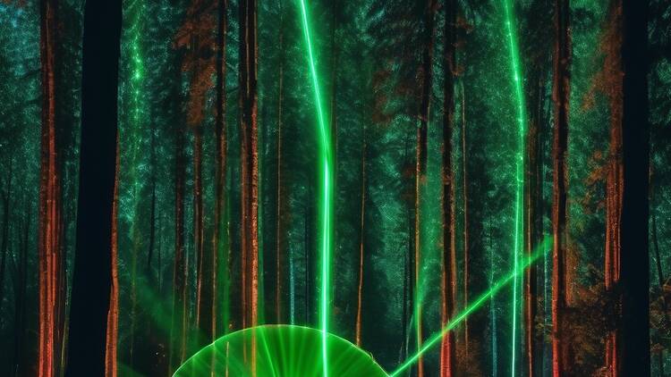 Two people standing in a forest surrounded by lasers. 