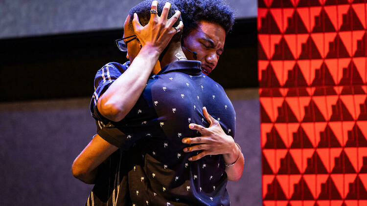 two people embrace on a stage