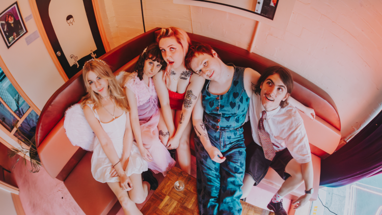 Five members of Oh Daisy seen from above, sitting close together on a couch