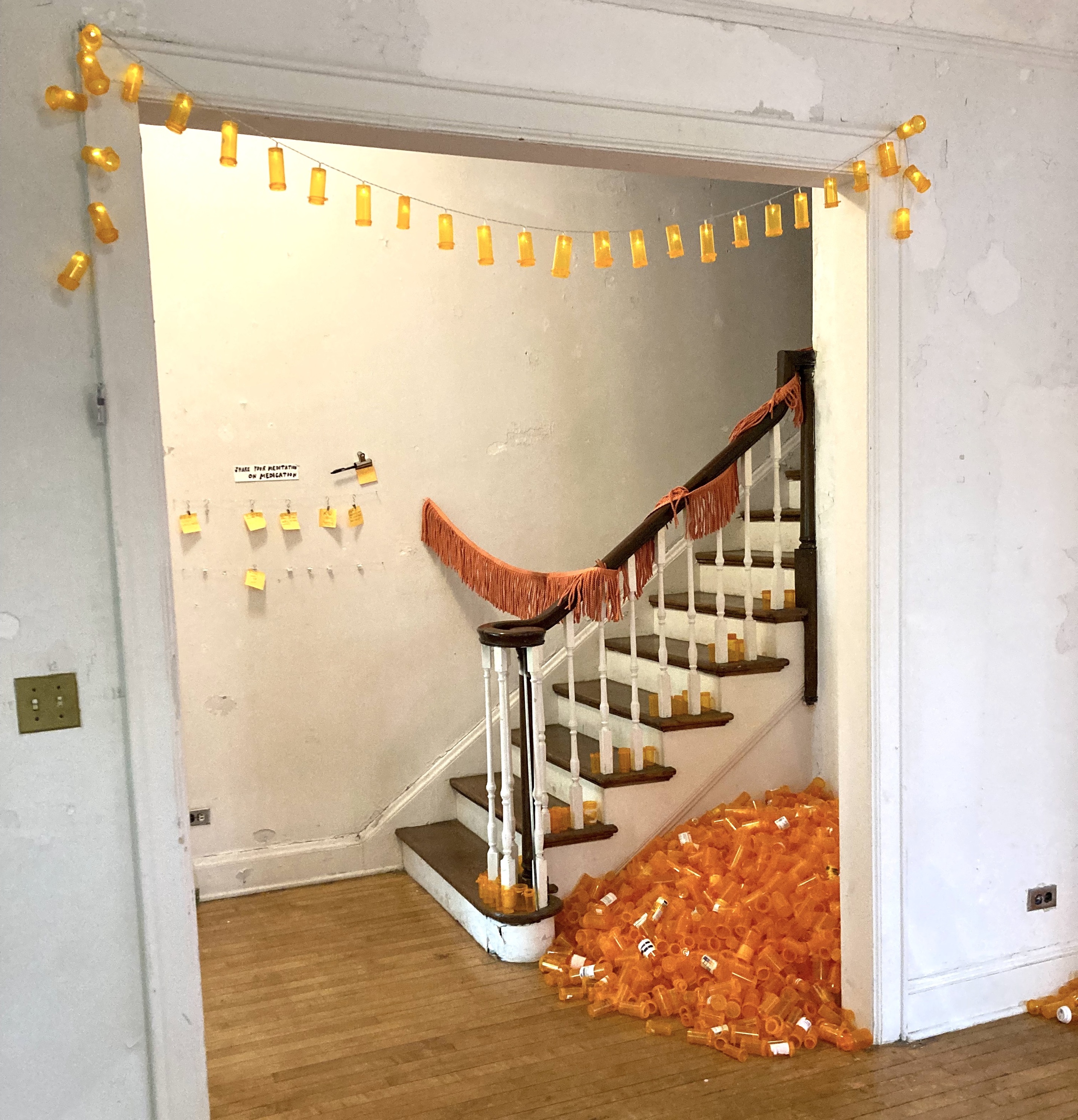 An art installation with orange plastic bottles.