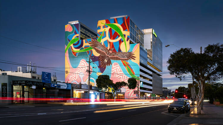 A brightly coloured mural on the side of a tall building.