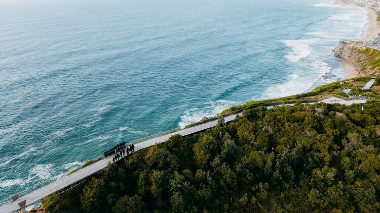 A aerial shot of a coastal walk along the ocean