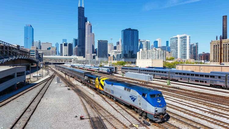 amtrak train in front of the chicago skyline