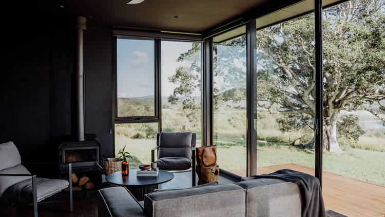 Dim living room with glass windows overlooking garden