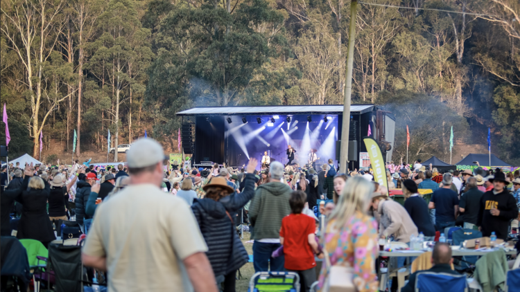 A busy festival with musicians performing on a stage