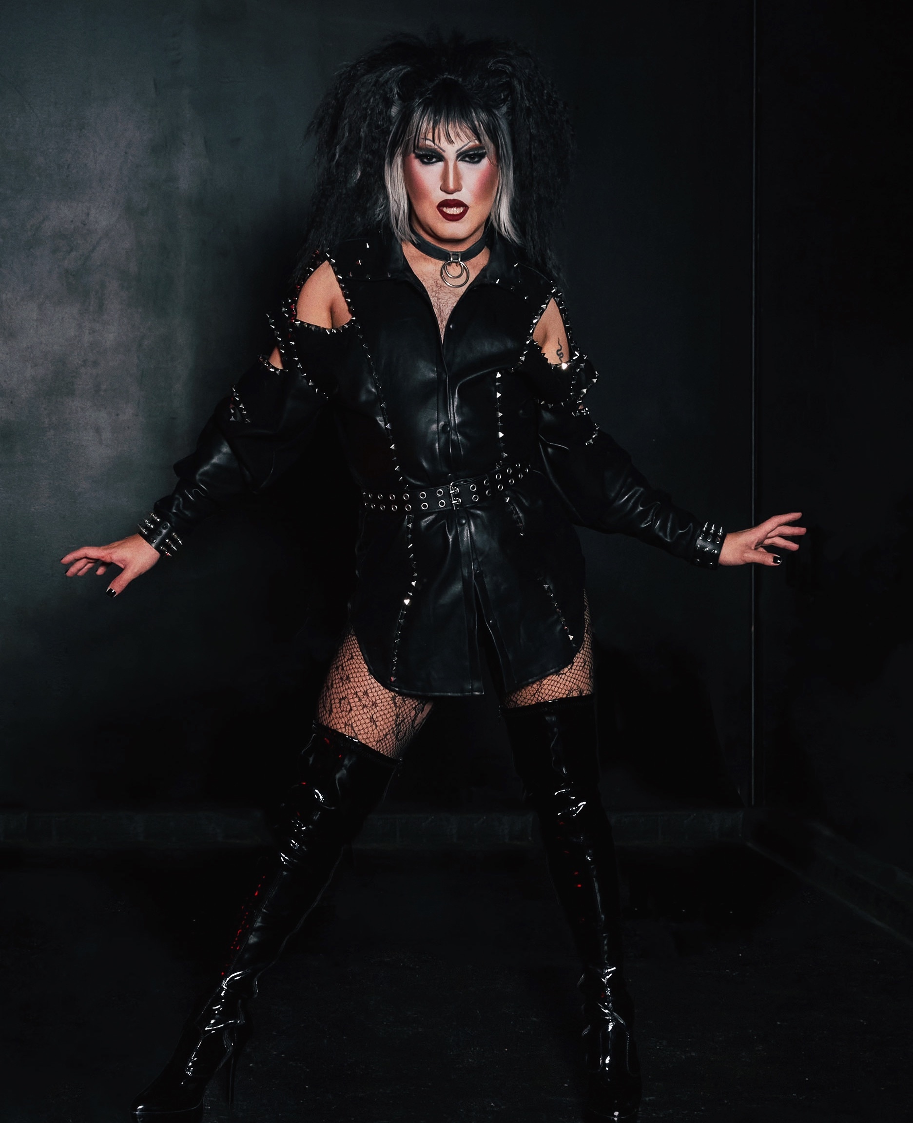 A drag performer in a black leather outfit.