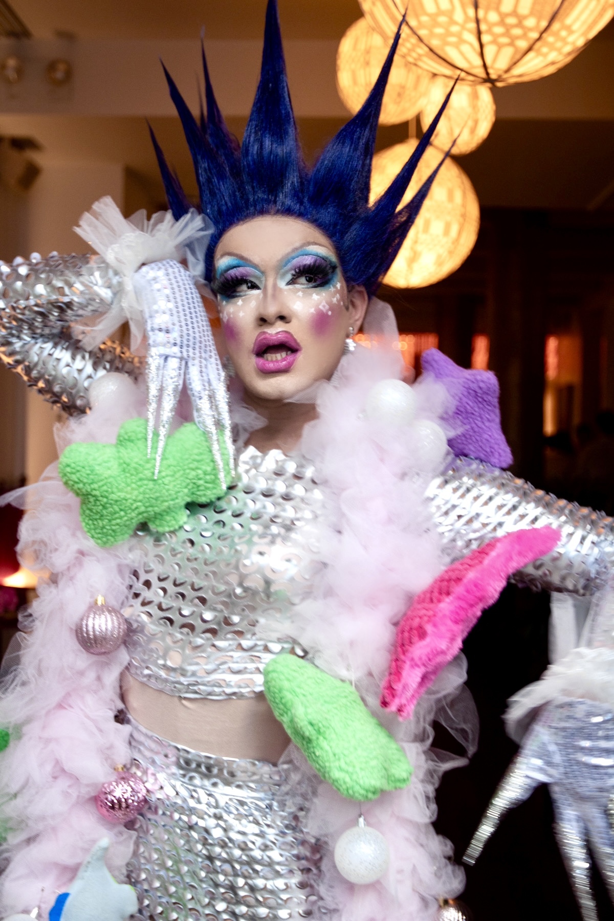 A drag performer with a purple/blue spiky wig.