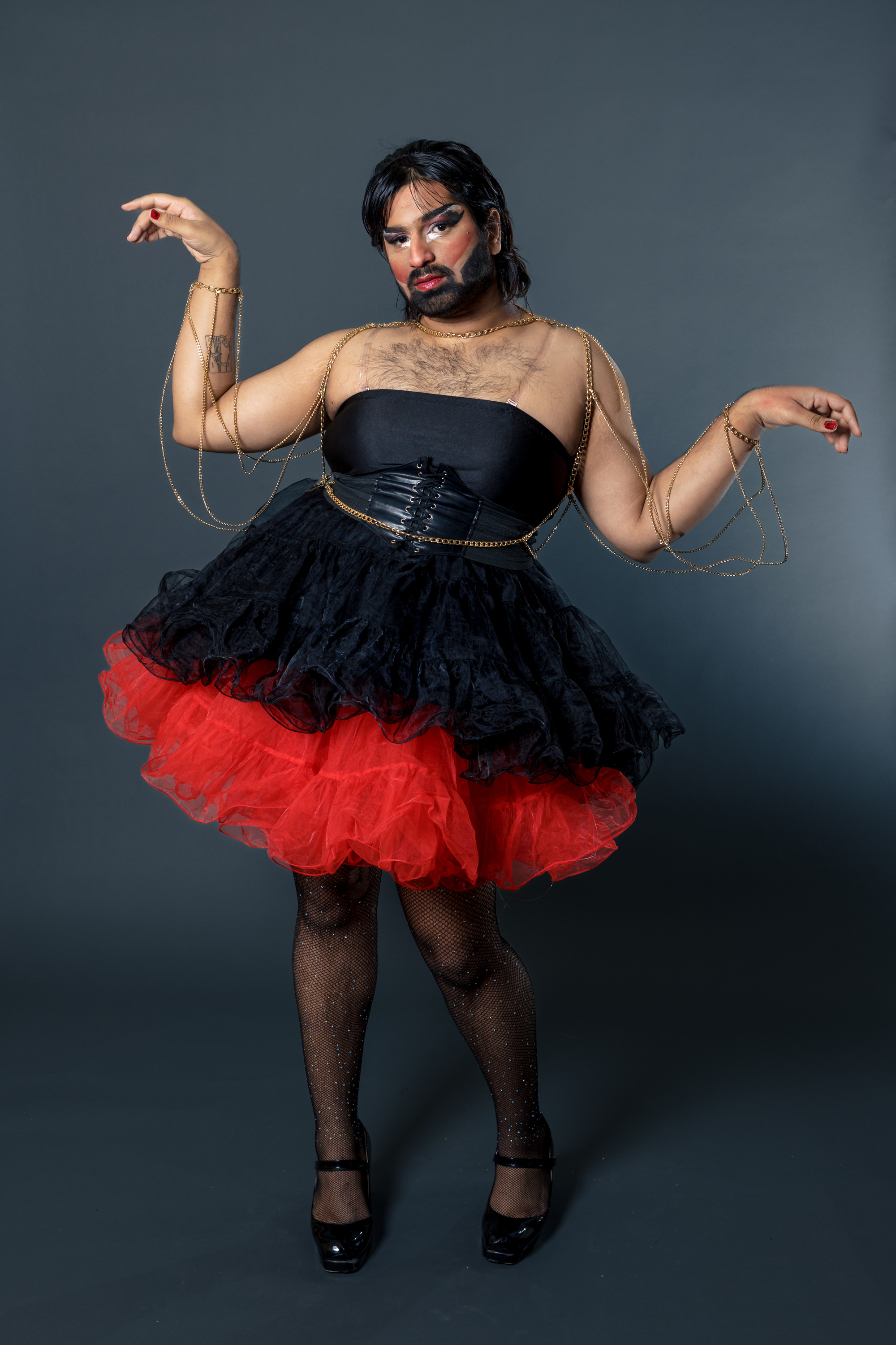 A drag queen poses in a black dress.