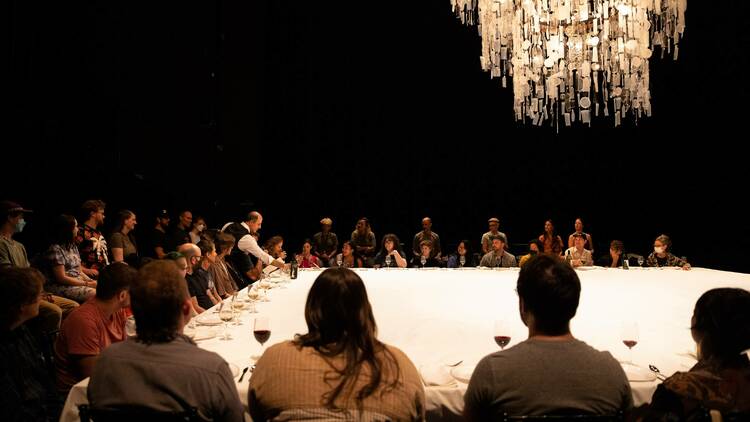 A waiter serves a huge table of people.